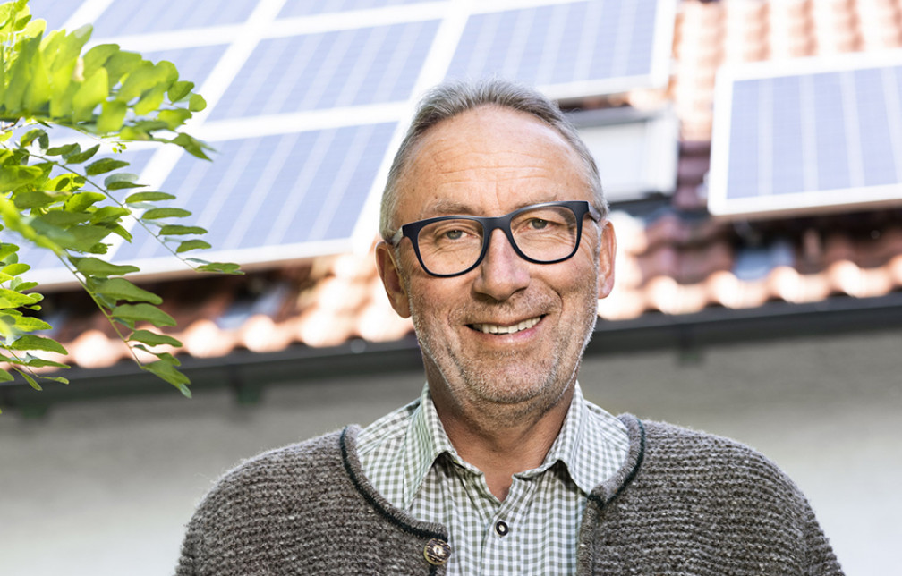 Hubert Fischer steht vor seinem Haus mit einer PV-Anlage